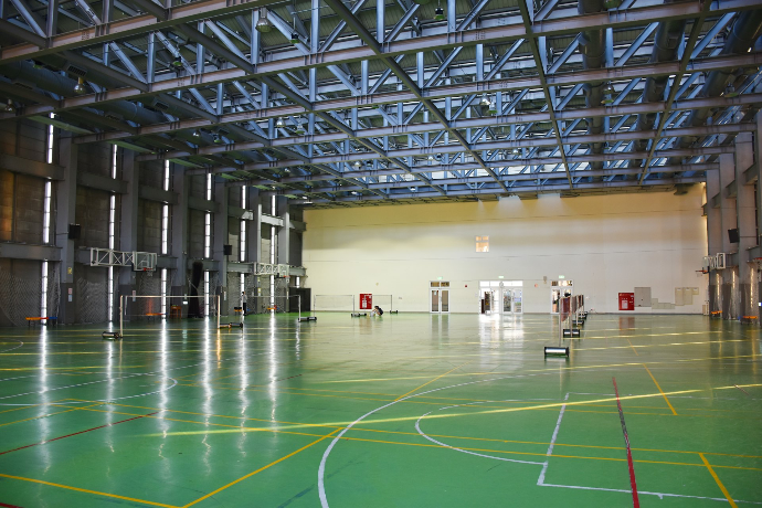 an indoor basketball court with green and yellow lines